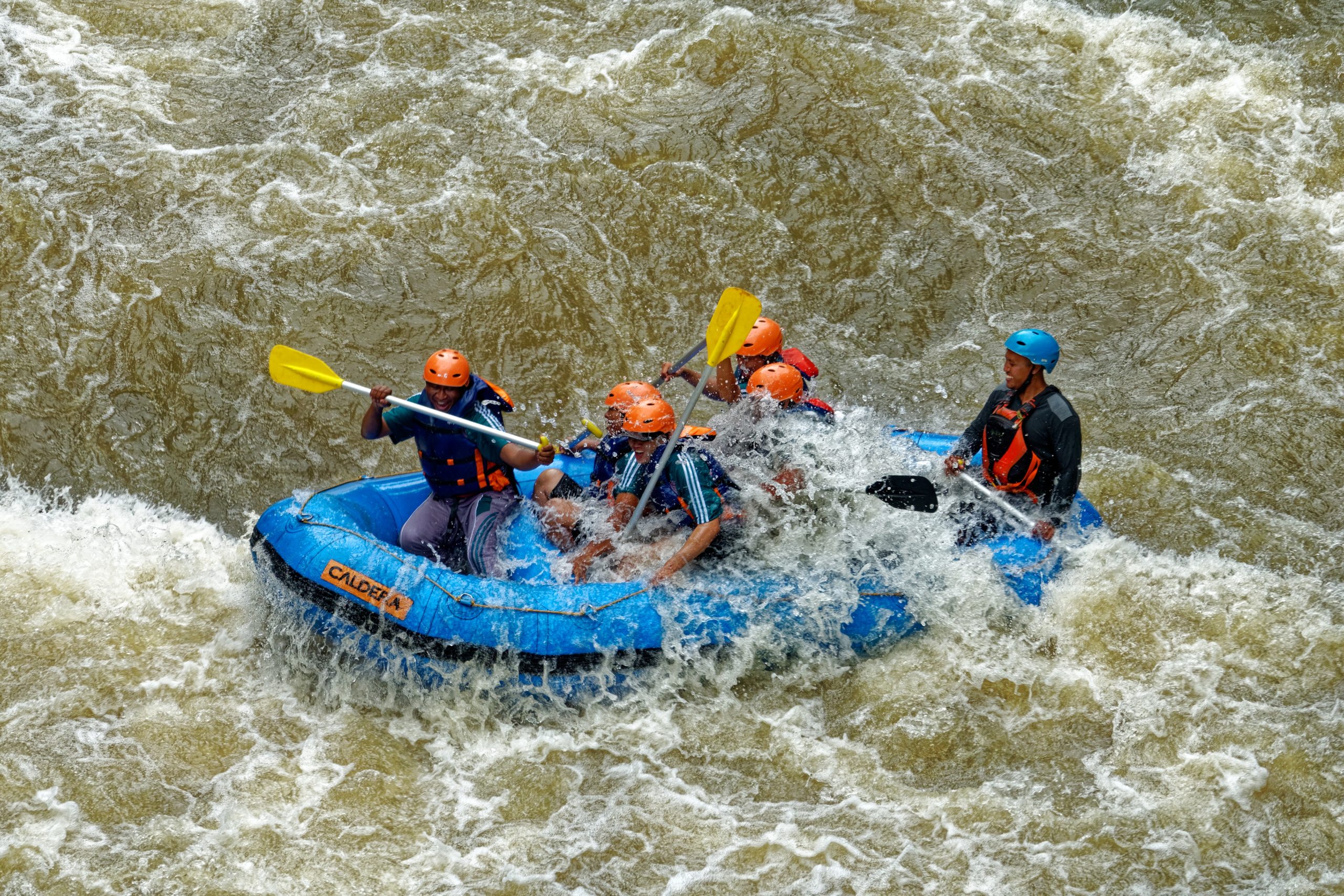 group of men rafting in white water